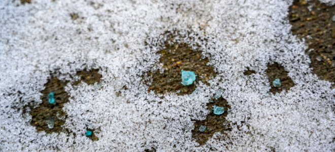 large blue salt melting ice on pavement