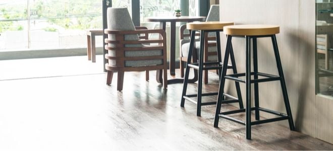 two backless bar stools in a kitchen near other chairs