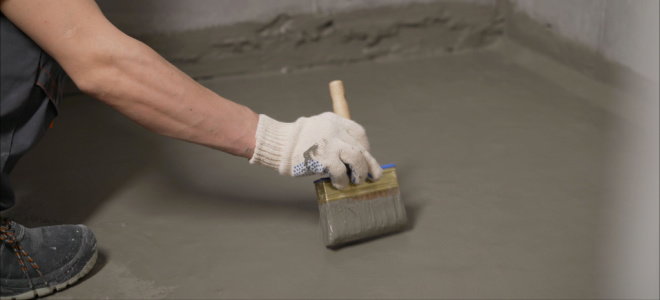 hand brushing waterproofing onto concrete