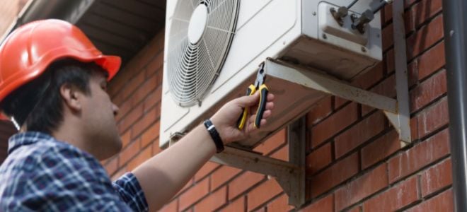 worker installing outdoor AC unit