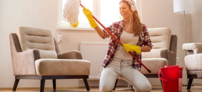 woman with headphones having fun while she gets ready to mop a floor