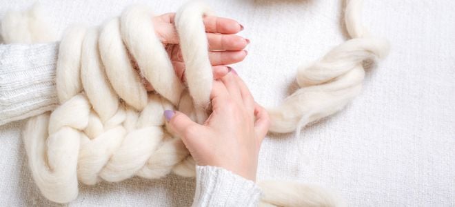 hands knitting white knot blanket