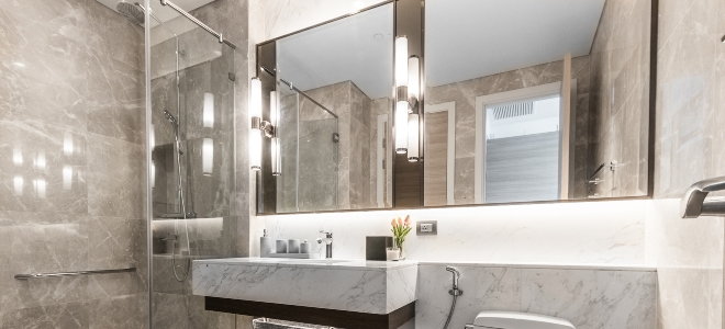 marble stone bathroom with large mirrors and light fixtures