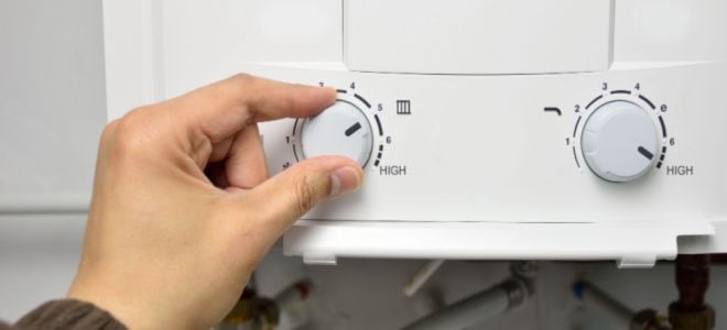 hand adjusting water heater temperature
