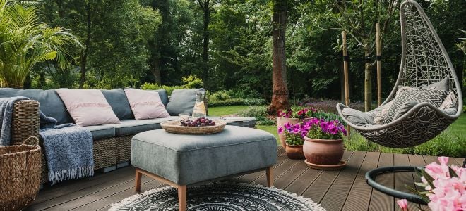 furniture on an outdoor deck in a yard with trees