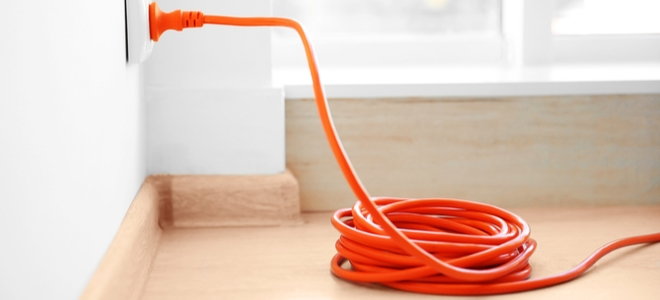 orange extension cord plugged into the wall