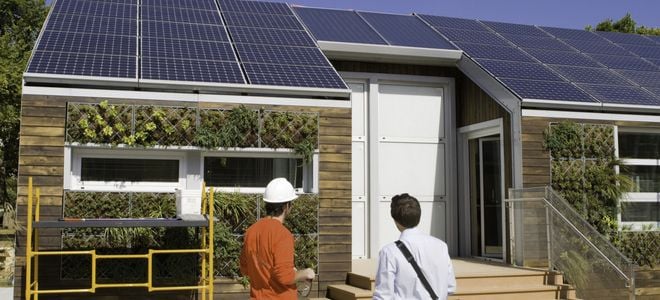 people looking at a house with solar panels on the roof