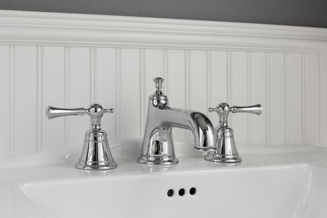 silver bathroom faucets mounted on a white sink