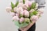 person holding a pot full of light pink hyacinth