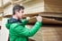 A man in a green jack choosing plywood.