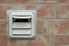 White dryer vent installed into an exterior brick wall