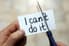 A piece of paper with the words "I can't do it" and a pair of scissors cutting the paper so it says "I can do it."