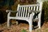 An unfinished, outdoor bench with mildew growth on the wood.