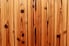 A row of knotty pine planks, nailed down.