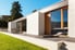 sleek, modern concrete house with sunny patio