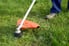 A weed eater being used to trim a lawn.