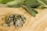 Fresh and dried sage leaves lay on a cutting board.