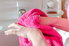 A woman uses a pink hand towel.