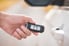 hand holding keyless entry fob by car door