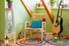 colorful room with eclectic design, circular rugs, plants, and a guitar