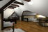 room with angled ceiling and dark wood beams