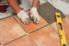 installing ceramic tile on the floor.
