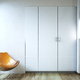 room with white bi-fold closet door and chair
