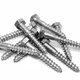A pile of hexagonal lag screws sits on a white background.