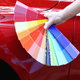 Paint swatches in front of a red car.