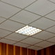 A square, fluorescent lighting fixture in a tiled ceiling.