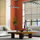 stylish contemporary living room with large, natural window shades, couches, and coffee table