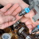 a hand touching the fuel injector on an engine