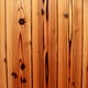 A row of knotty pine planks, nailed down.