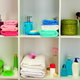 Hand towels and soaps neatly organized on bathroom shelves.