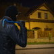 A burglar looking at a house at night.