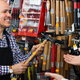 smiling salesman handing customer a hammer in a hardware store