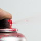 Red spray paint coming from a paint can nozzle.