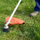 A weed eater being used to trim a lawn.
