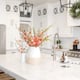 light, open farmhouse kitchen with sink island featuring pink flowers in vases