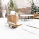 A snow-covered deck in a yard. 