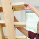 man building set of narrow loft stairs