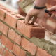Brick and mortar being laid into a wall.