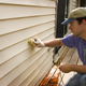 a person repairing home siding