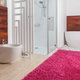 stylish bathroom with colorful rug and wood walls