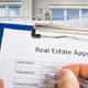 hand with clipboard conducting real estate appraisal