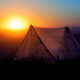 A tent against a sunrise. 