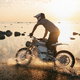 A man riding a dirt bike at sunset