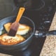 A frying pan cooking on a glass top stove.