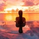 woman in infinity pool watching sunset