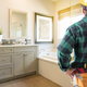 man with tools looking at remodeled bathroom